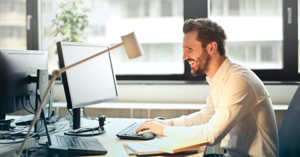 A smiling freelancer emailing a client his value proposition